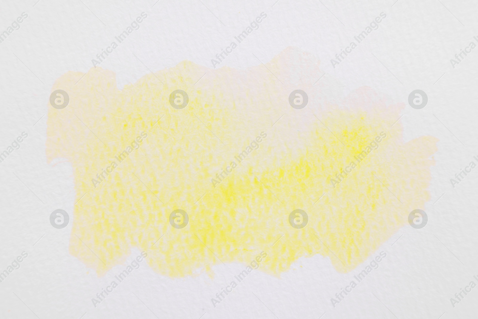 Photo of Abstract yellow watercolor painting on white paper, top view