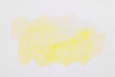 Photo of Abstract yellow watercolor painting on white paper, top view