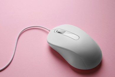 One wired mouse on pink background, closeup