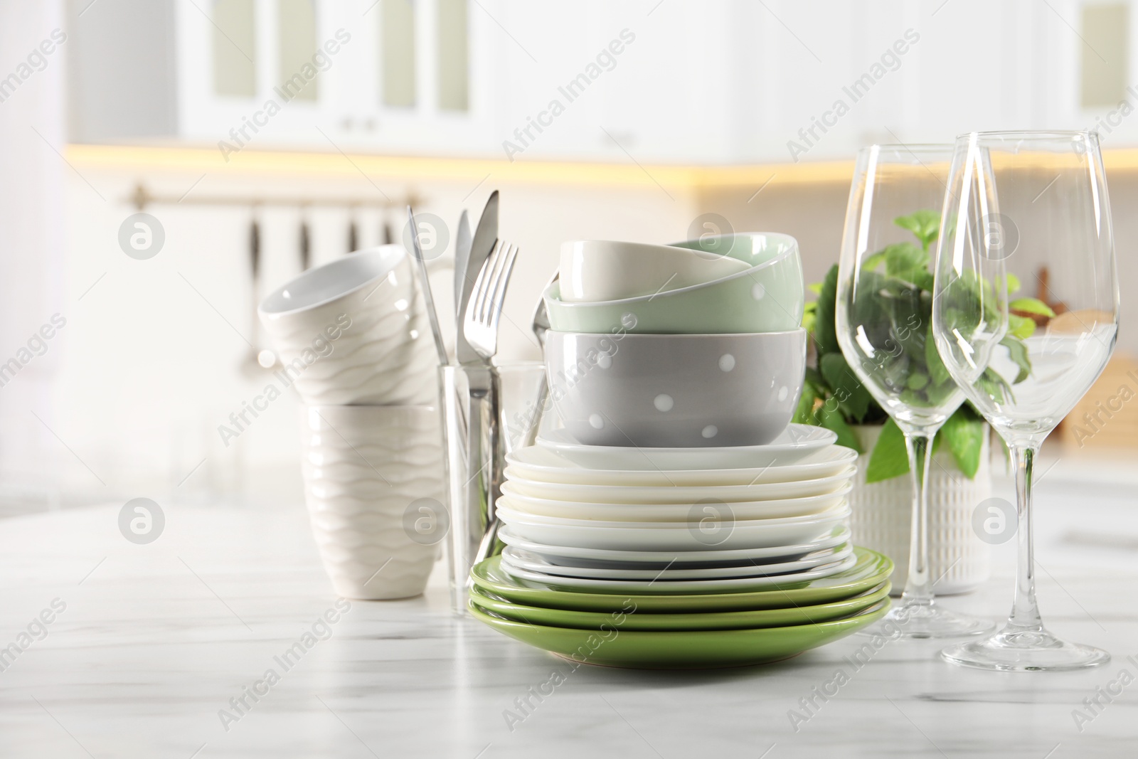 Photo of Many different clean dishware, glasses, cups and cutlery on white marble table indoors. Space for text