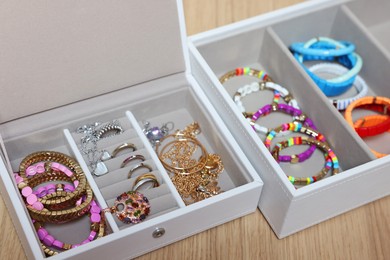 Photo of Jewelry boxes with stylish bracelets and other accessories on wooden table