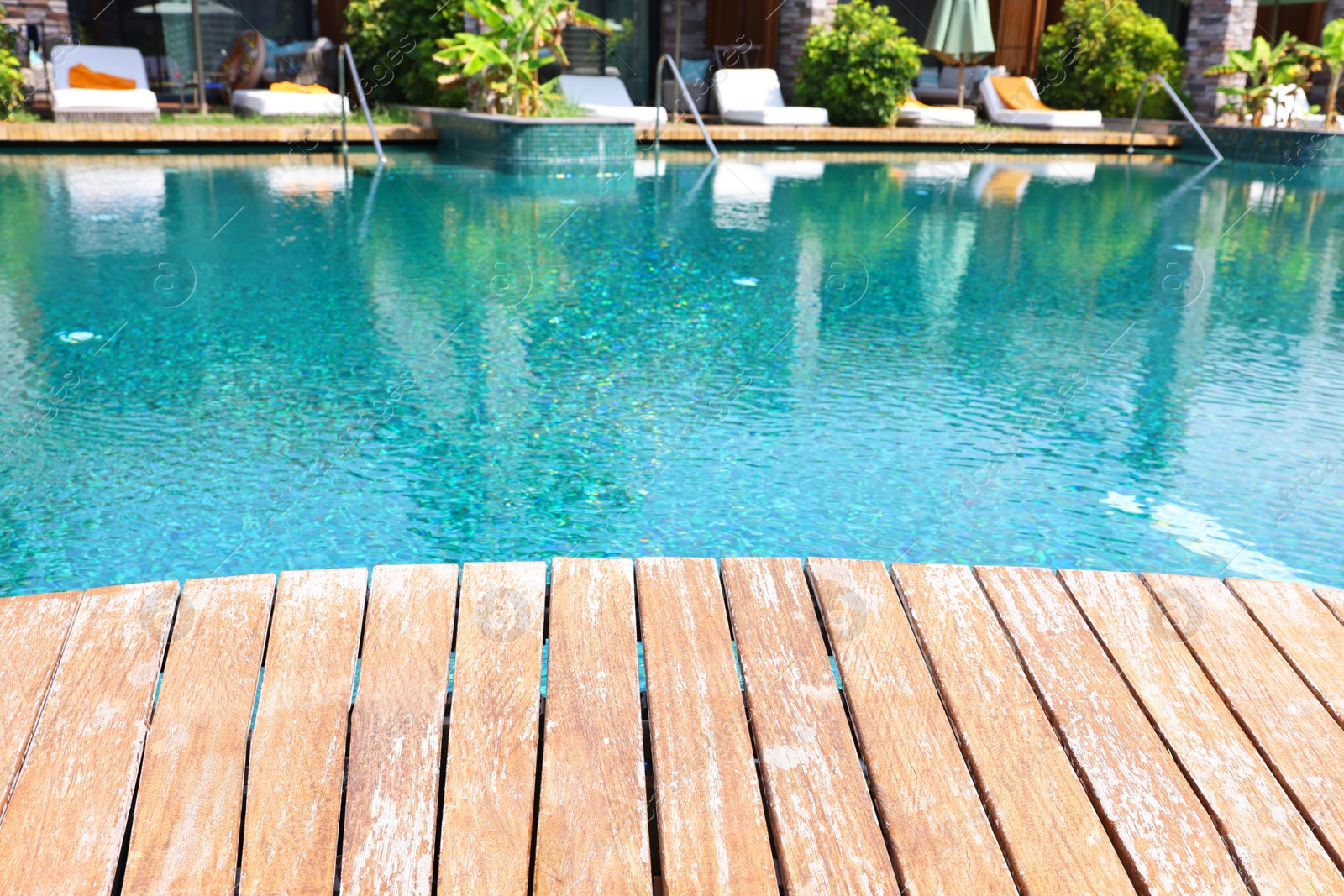 Photo of Outdoor swimming pool with wooden deck and sunbeds at resort