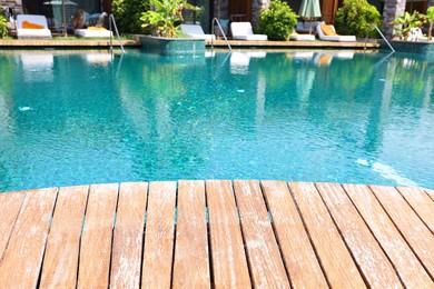 Photo of Outdoor swimming pool with wooden deck and sunbeds at resort