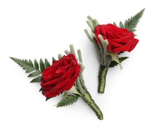 Two stylish red boutonnieres isolated on white, top view