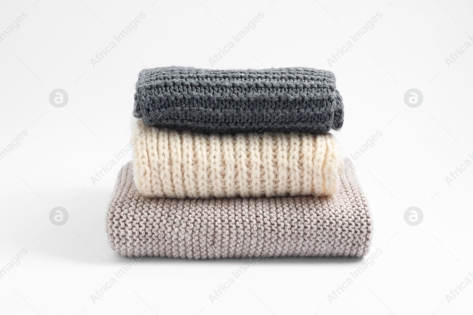 Photo of Stack of knitted scarfs on white background