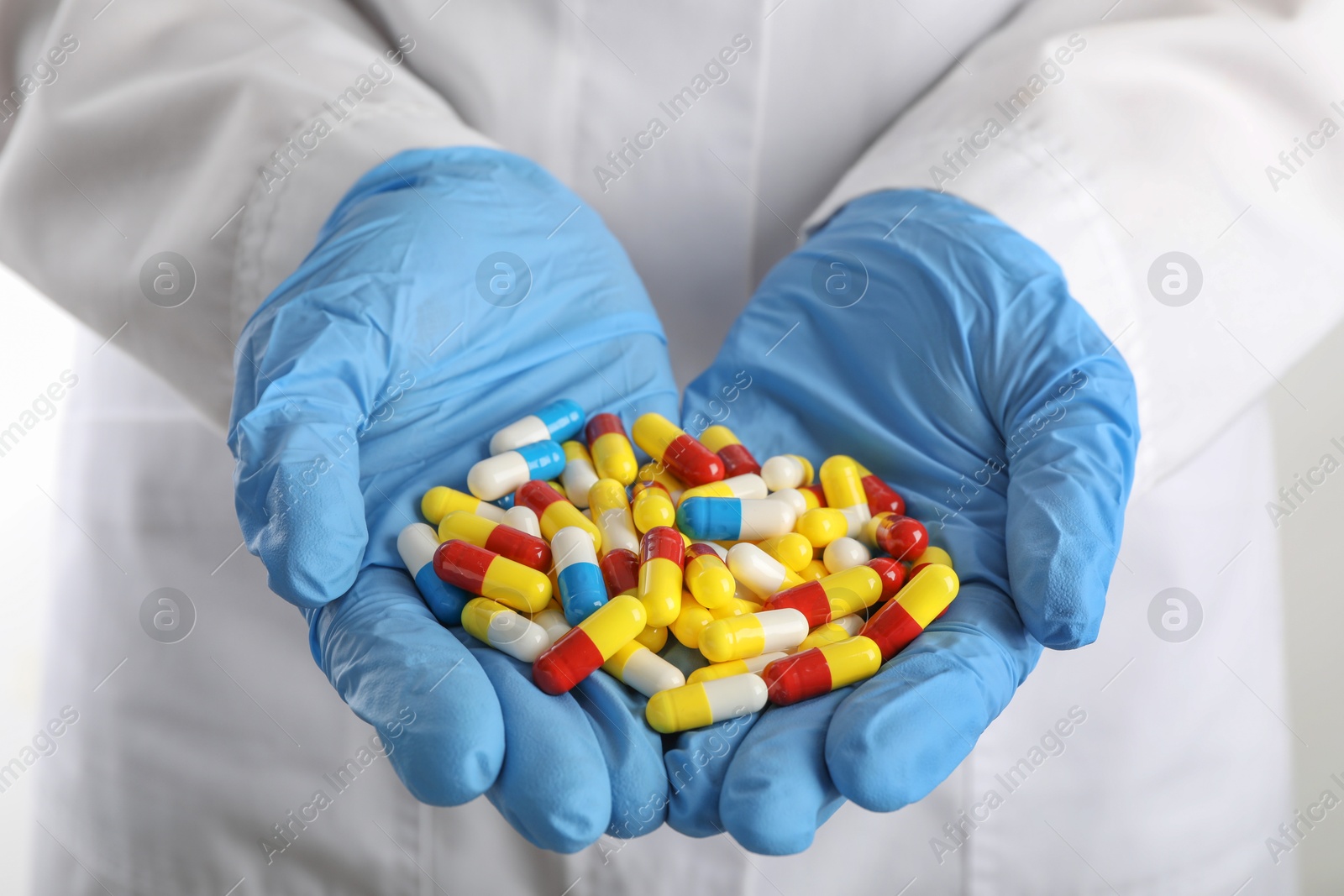 Photo of Woman holding many antibiotic pills, closeup. Medicinal treatment