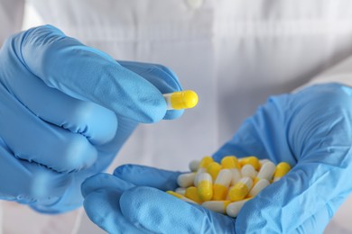 Photo of Woman holding many antibiotic pills, closeup. Medicinal treatment