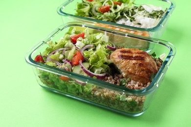 Photo of Healthy meal. Different products in glass containers on green background