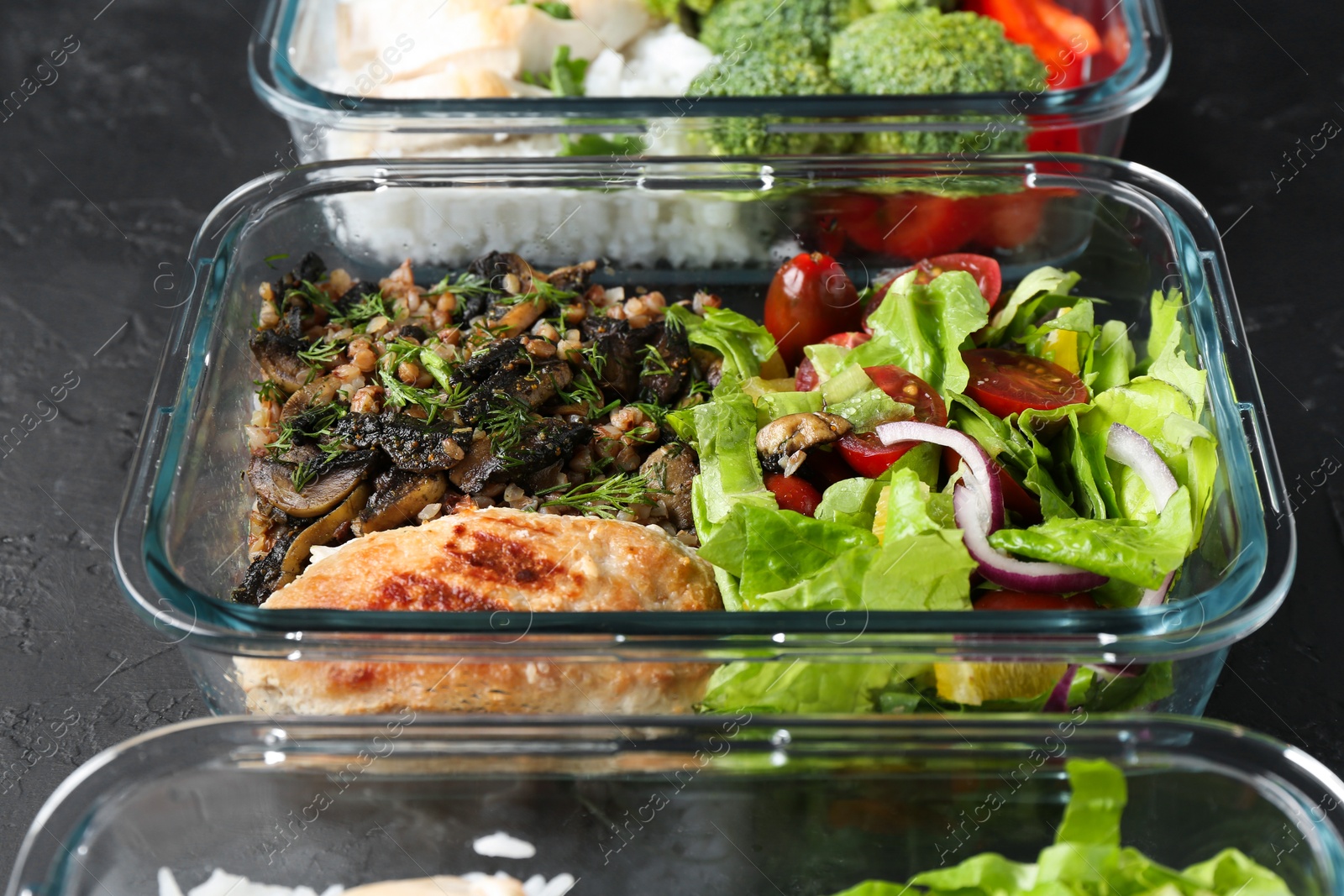 Photo of Healthy food. Different meals in glass containers on black table