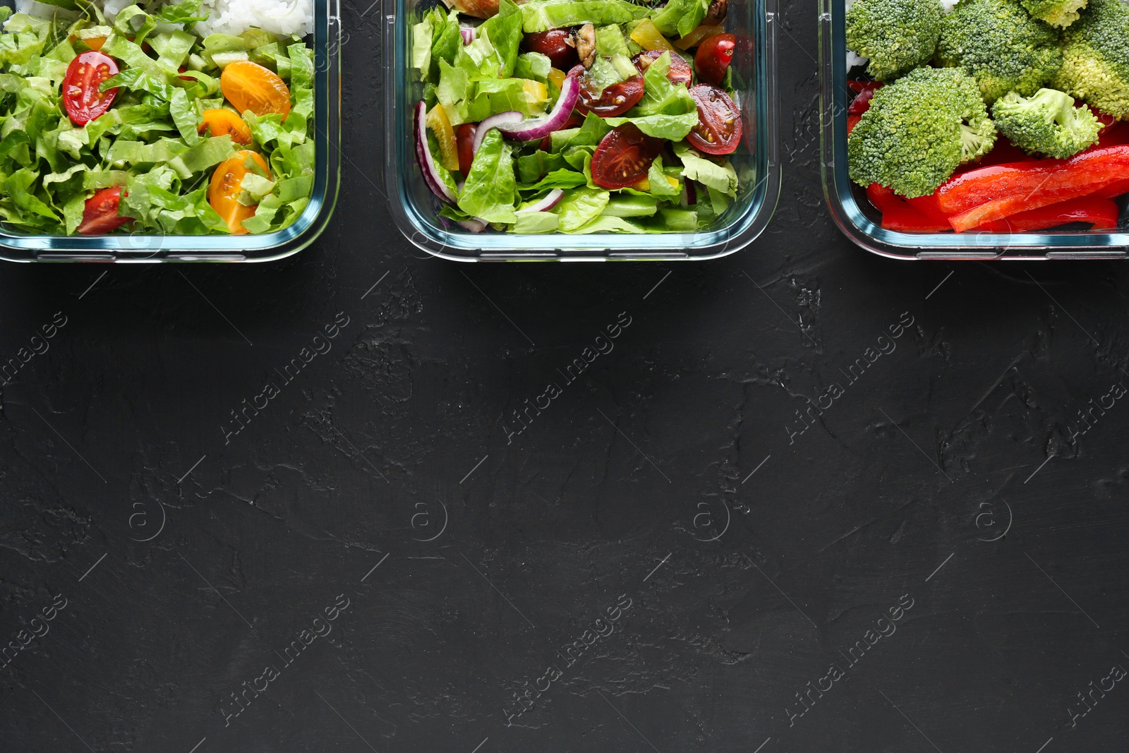 Photo of Healthy food. Different meals in glass containers on black table, flat lay. Space for text