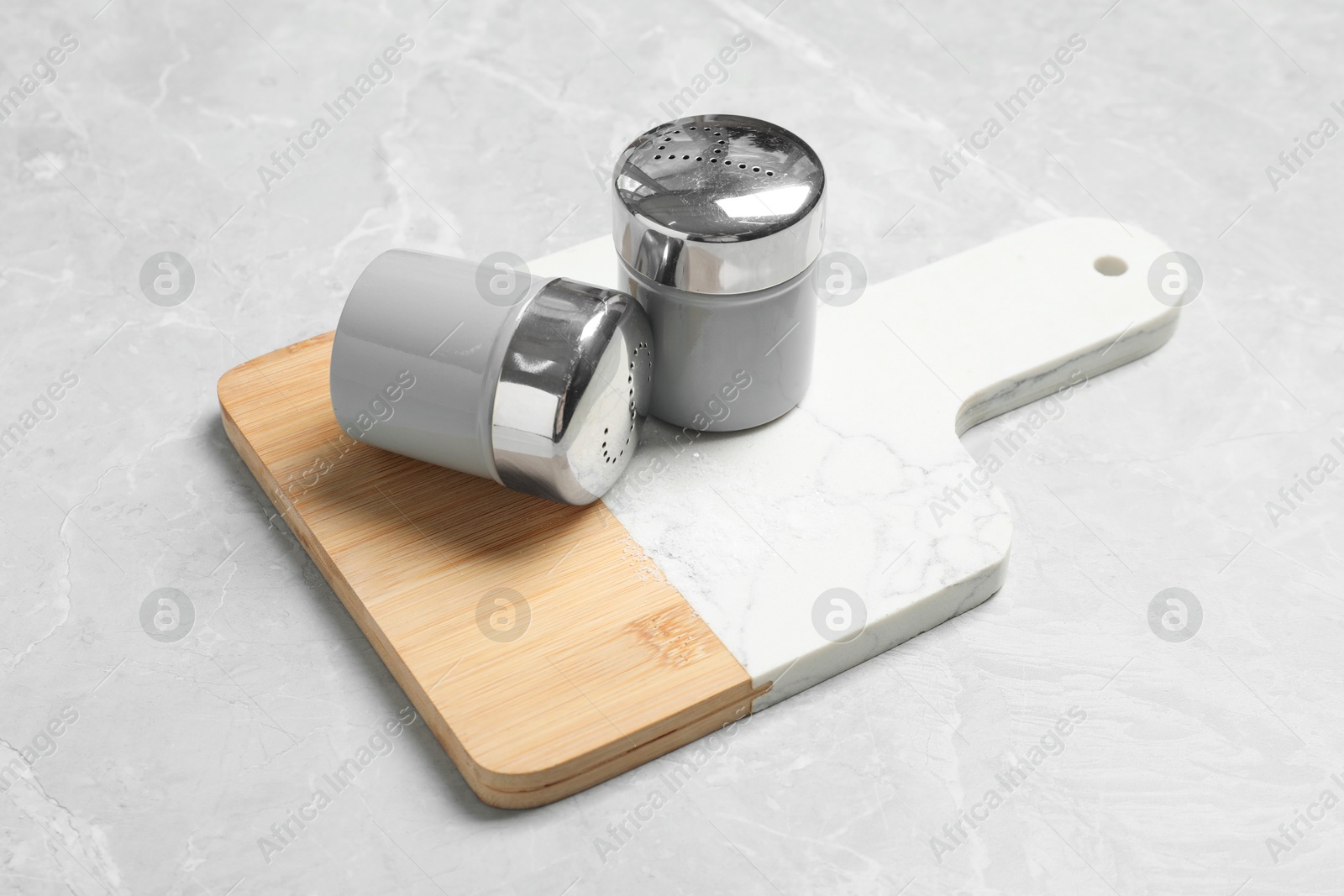 Photo of Salt and pepper shakers on grey marble table