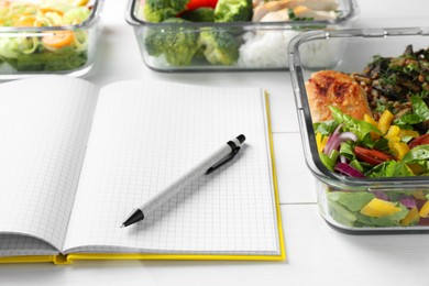 Photo of Healthy meal. Open notebook and containers with different products on white wooden table