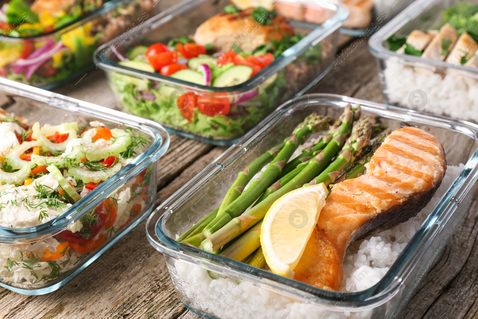 Photo of Healthy meal. Containers with different products on wooden table, closeup