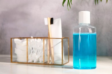 Bottle of mouthwash on white table in bathroom