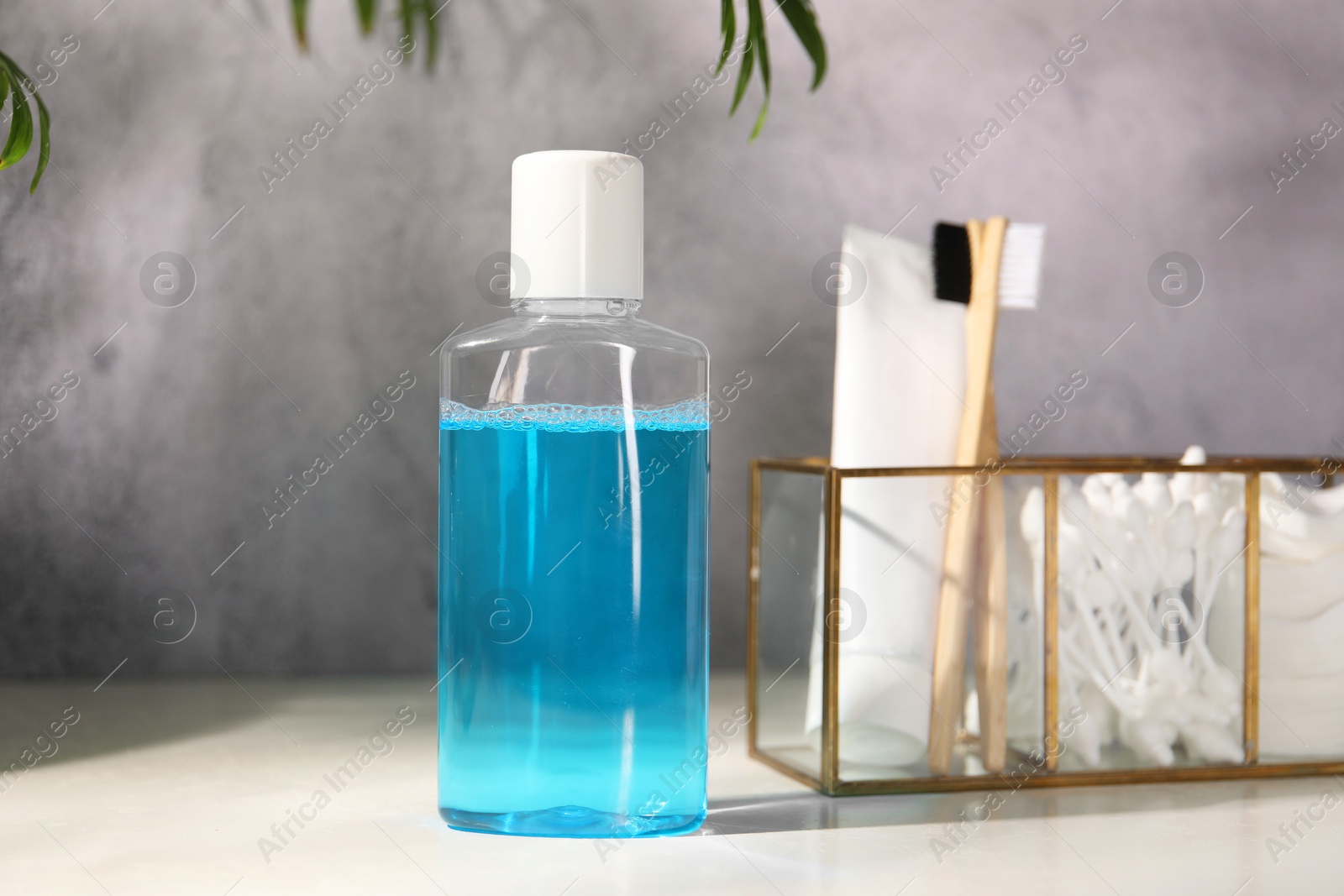 Photo of Bottle of mouthwash on white table in bathroom