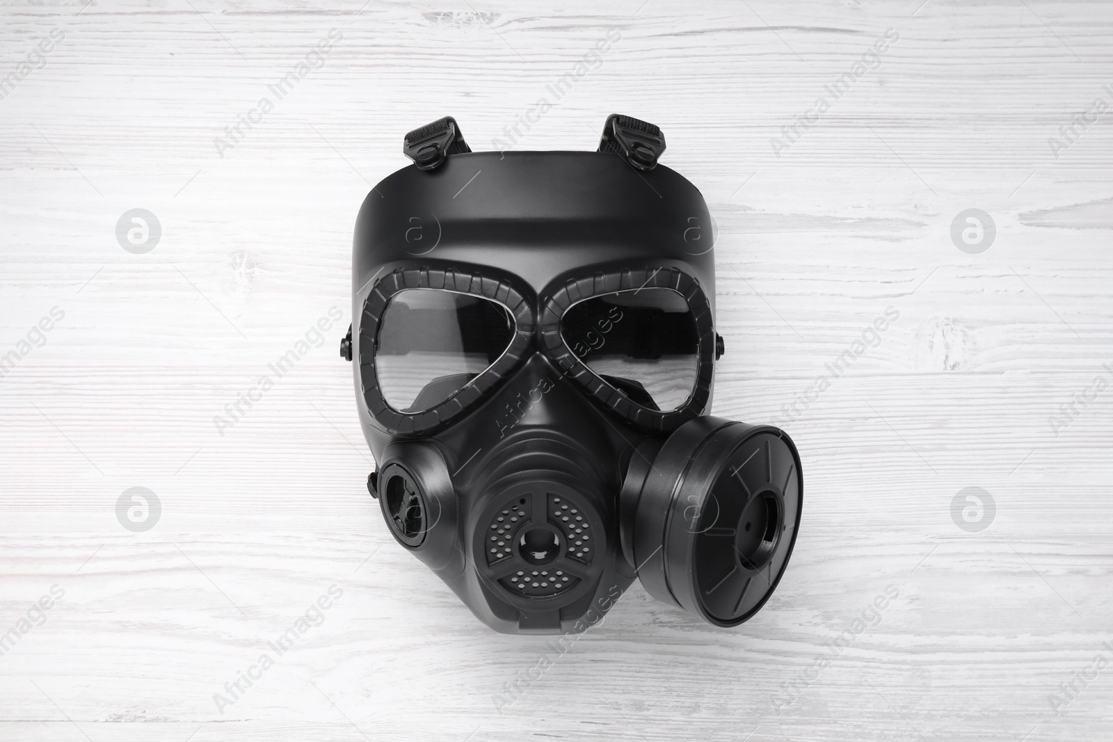Photo of One gas mask on white wooden background, top view