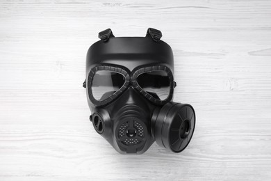 One gas mask on white wooden background, top view