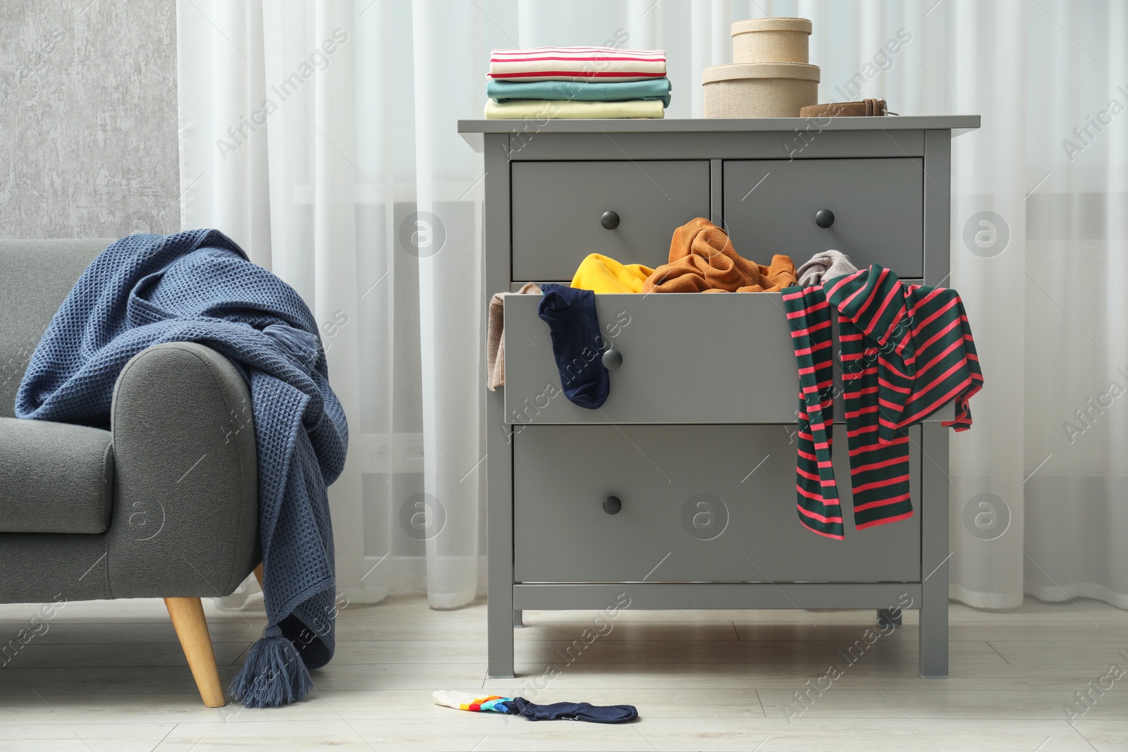 Photo of Cluttered room. Clothes in mess all around place