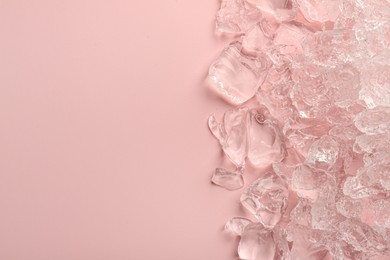 Pieces of crushed ice on pink background, top view. Space for text