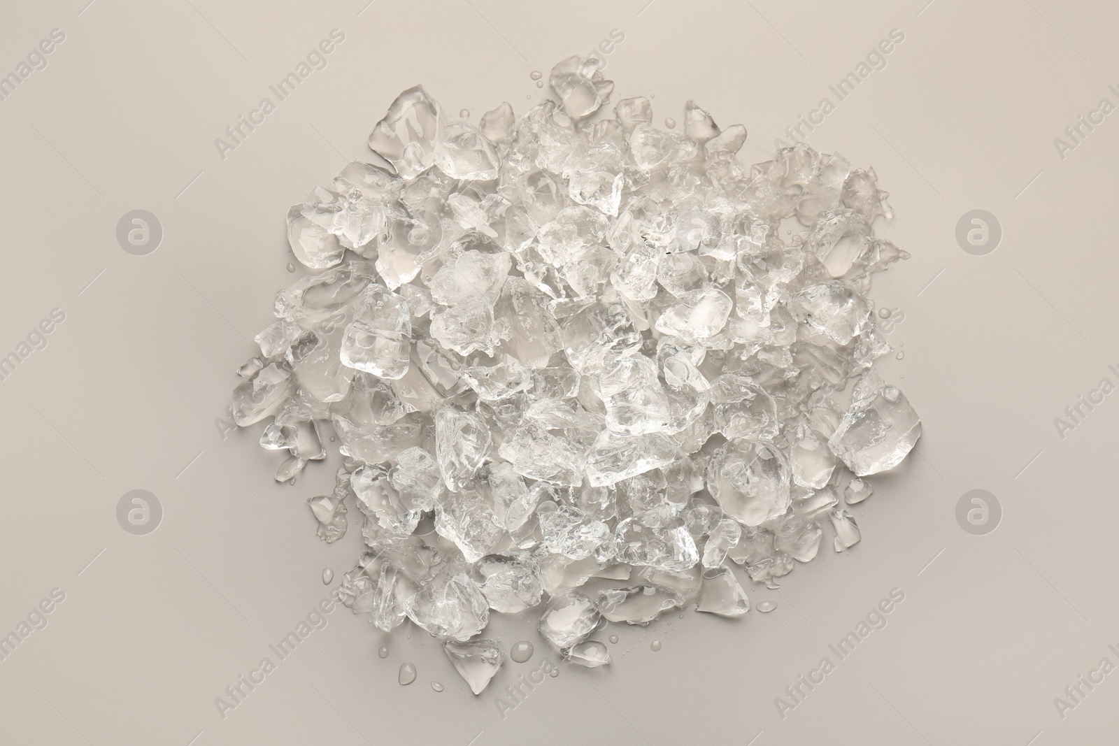 Photo of Pieces of crushed ice on grey background, top view