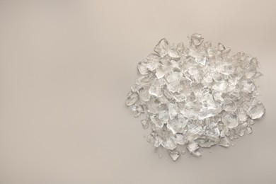 Pieces of crushed ice on grey background, top view. Space for text