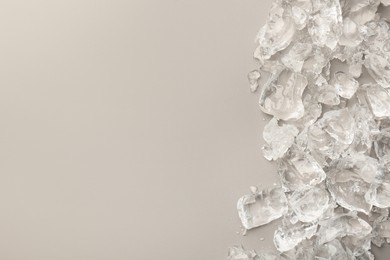 Pieces of crushed ice on grey background, top view. Space for text