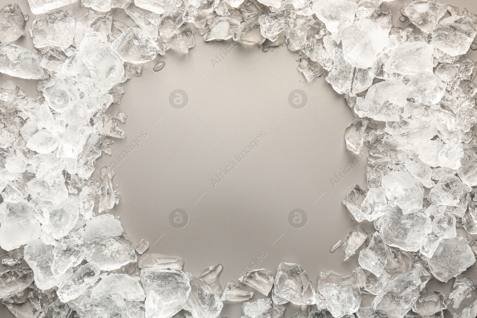 Photo of Frame of crushed ice on grey background, top view. Space for text