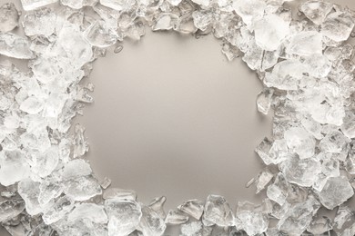 Frame of crushed ice on grey background, top view. Space for text