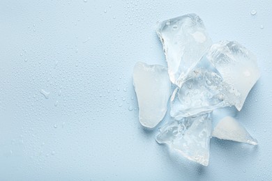 Pieces of crushed ice on light blue background