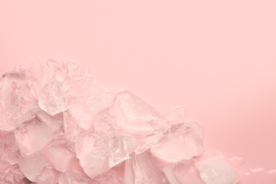 Photo of Pieces of crushed ice on pink background, top view. Space for text