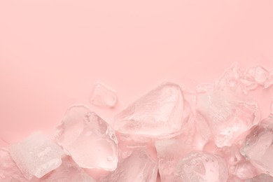 Photo of Pieces of crushed ice on pink background, top view. Space for text