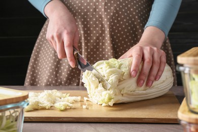 Photo of Healthy food. Woman cutting Chinese cabbage at grey table, closeup