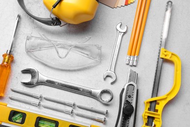 Flat lay composition with building level and other construction tools on grey table