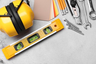 Photo of Flat lay composition with building level and other construction tools on grey table, space for text