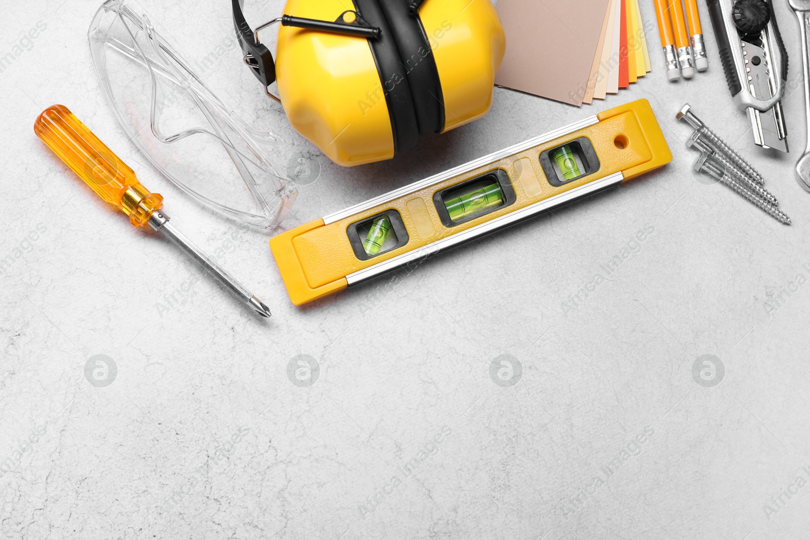Photo of Flat lay composition with building level and other construction tools on grey table, space for text