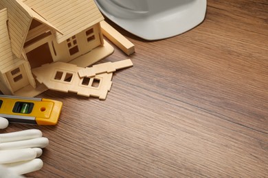 Photo of Building level and other construction tools on wooden table, above view. Space for text