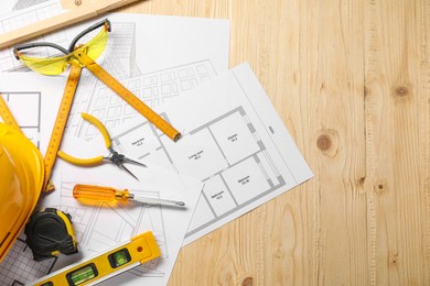 Photo of Flat lay composition with building level and other different construction tools on wooden background, space for text