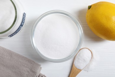 Photo of Baking soda and lemon on white wooden table, flat lay