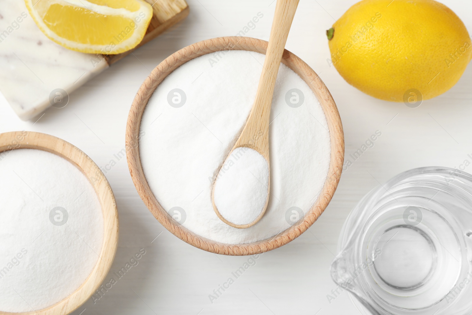 Photo of Baking soda, vinegar and lemons on white wooden table, flat lay