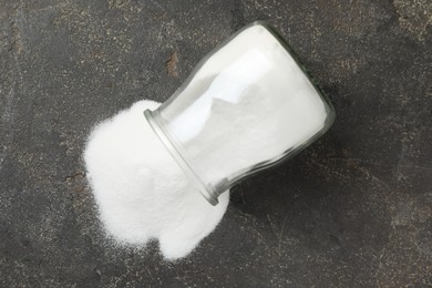 Photo of Baking soda in glass jar on grey table, top view