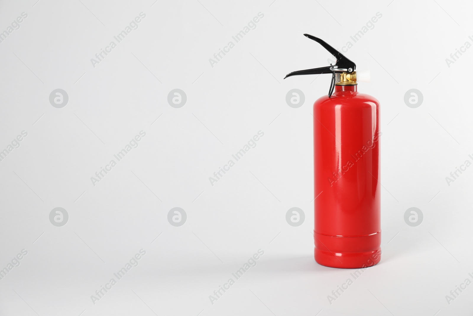 Photo of One red fire extinguisher on white background, space for text