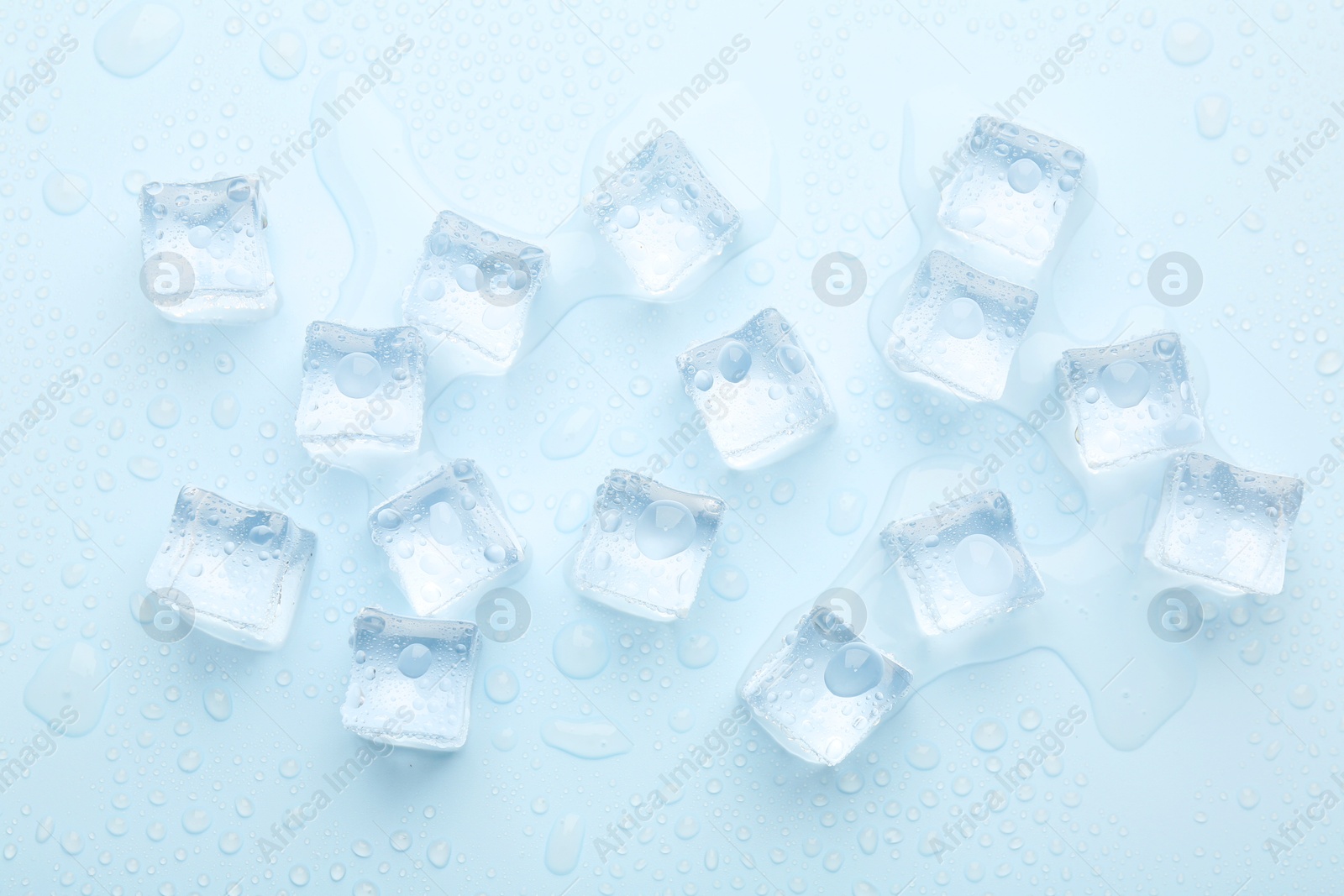 Photo of Crystal clear ice cubes on light blue background, flat lay