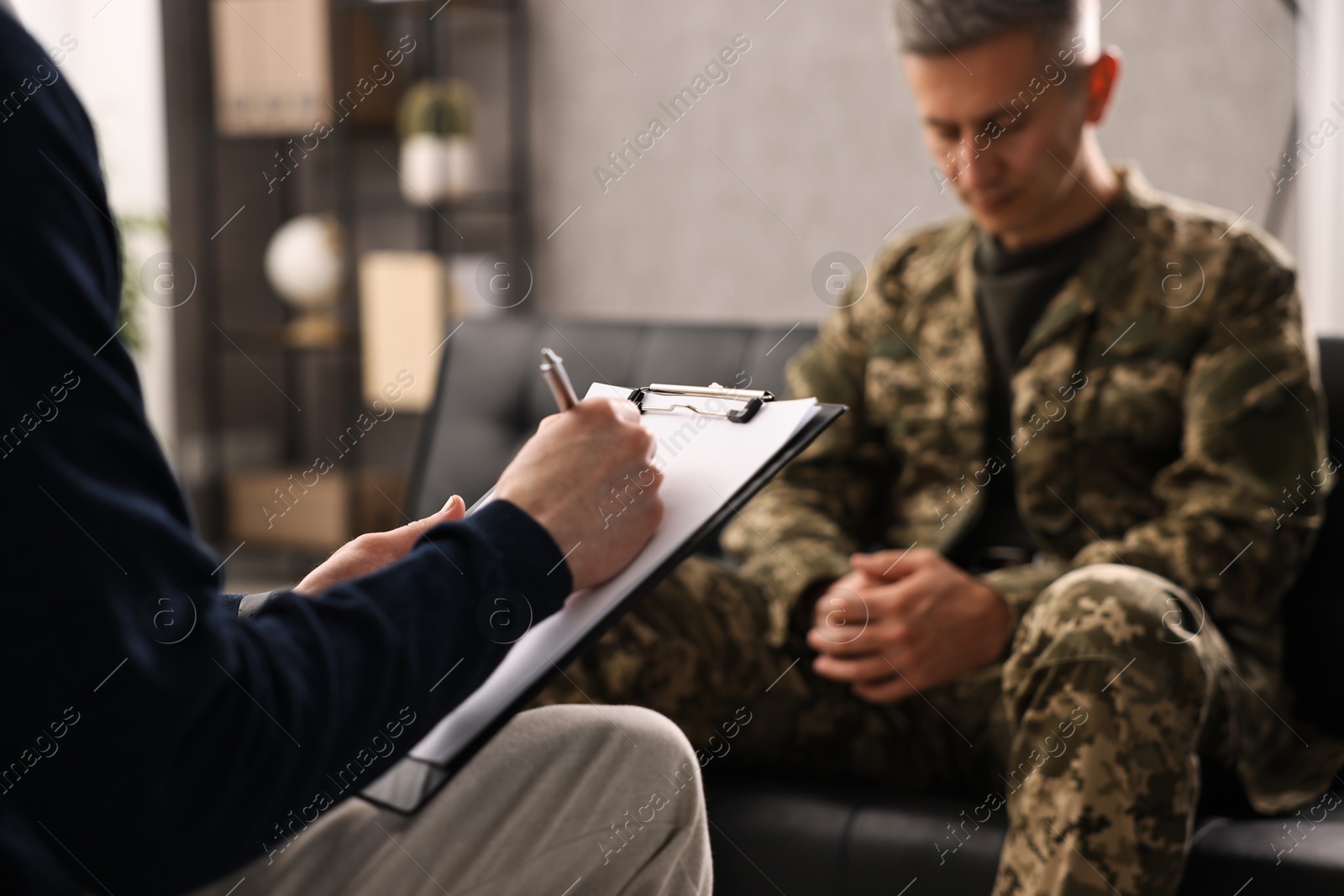 Photo of Professional psychotherapist working with military man in office, closeup