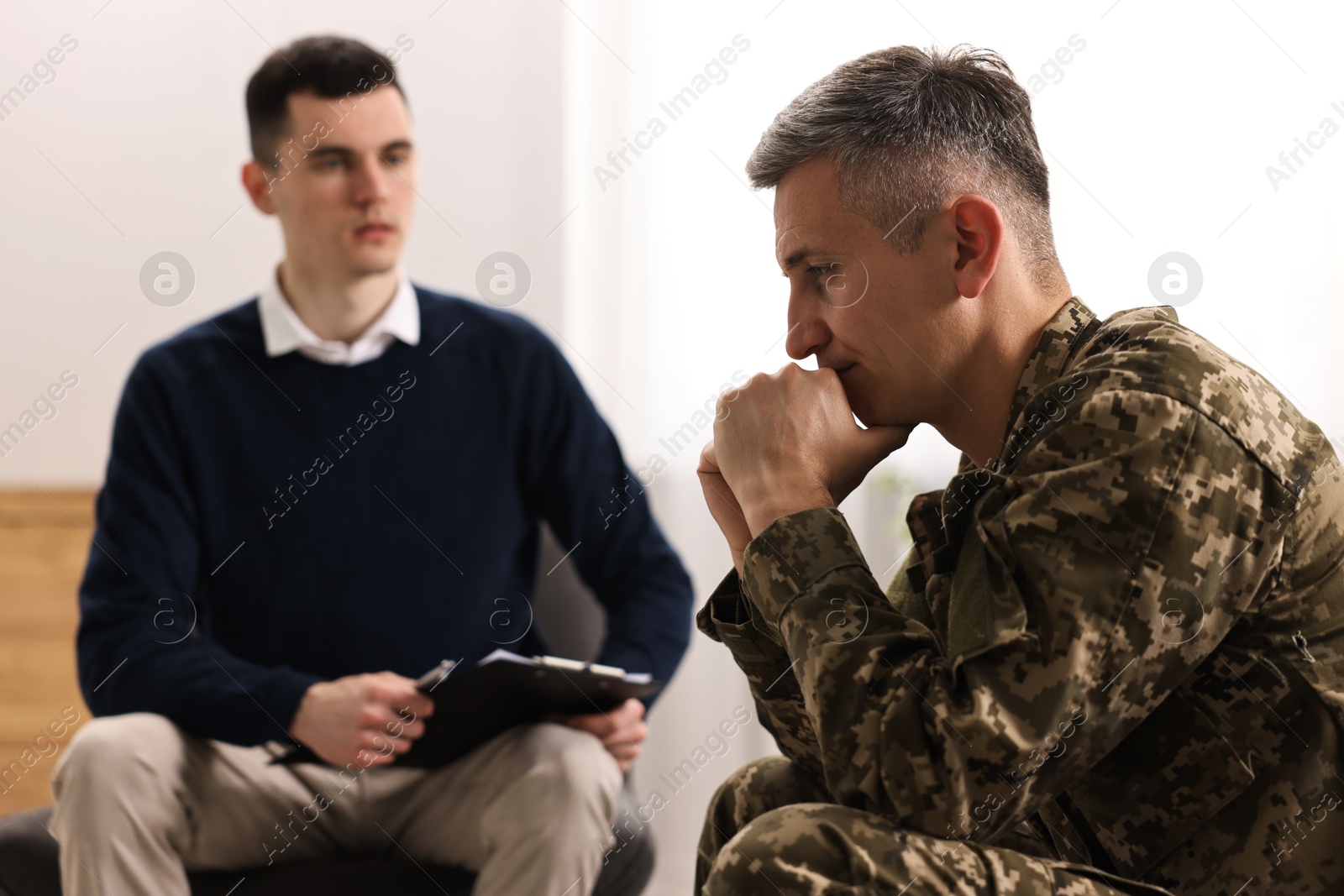 Photo of Professional psychotherapist working with military man in office