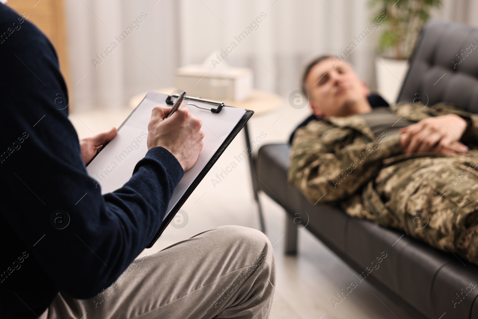 Photo of Professional psychotherapist working with military man in office