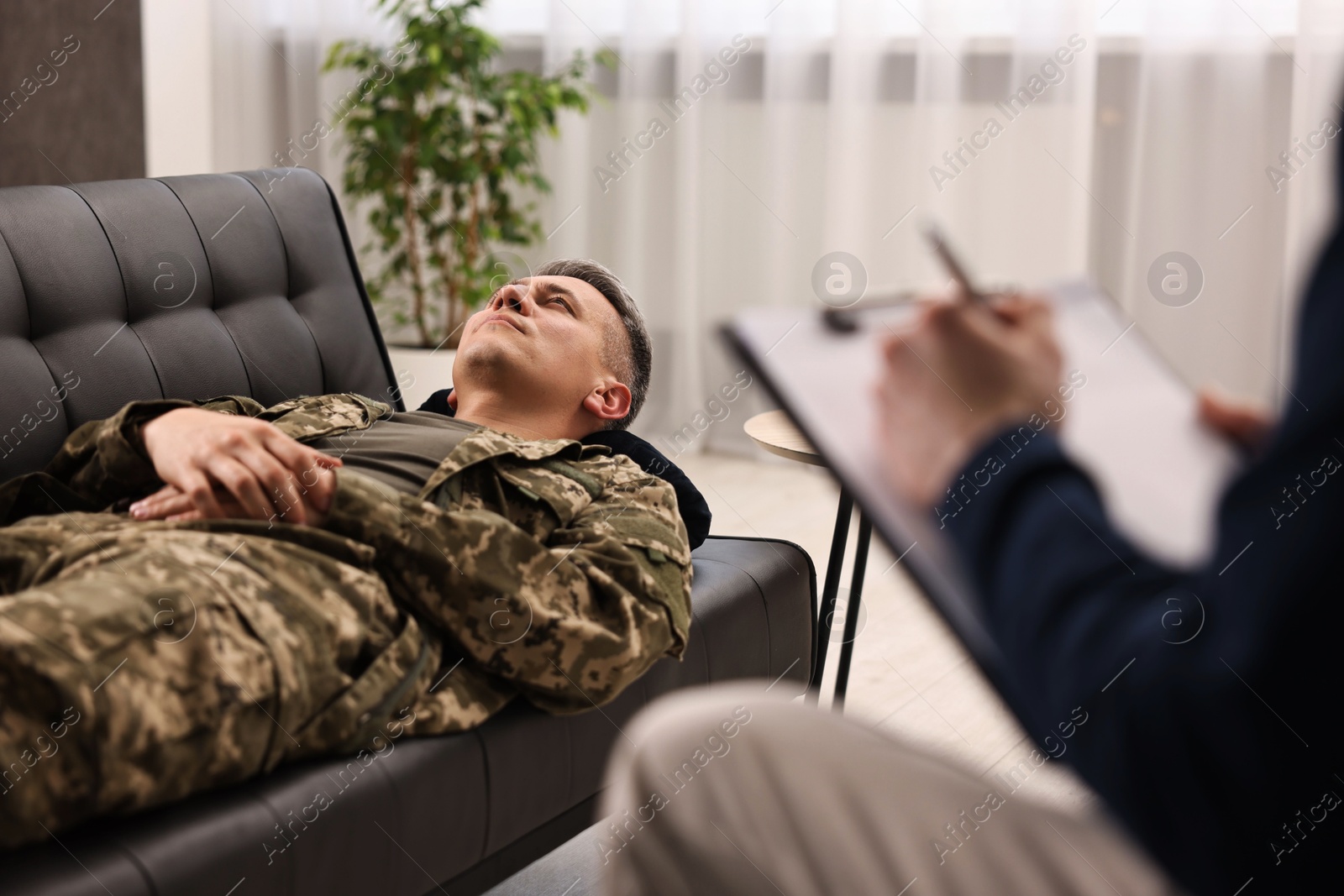 Photo of Professional psychotherapist working with military man in office