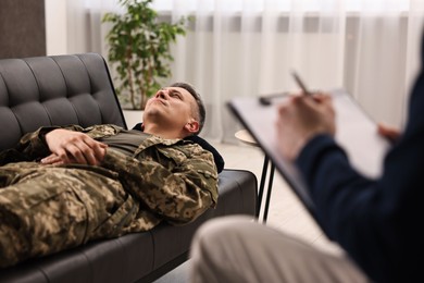 Photo of Professional psychotherapist working with military man in office