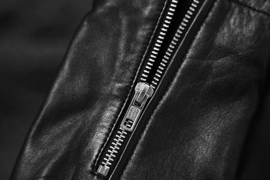 Photo of Texture of black leather jacket with zipper as background, top view