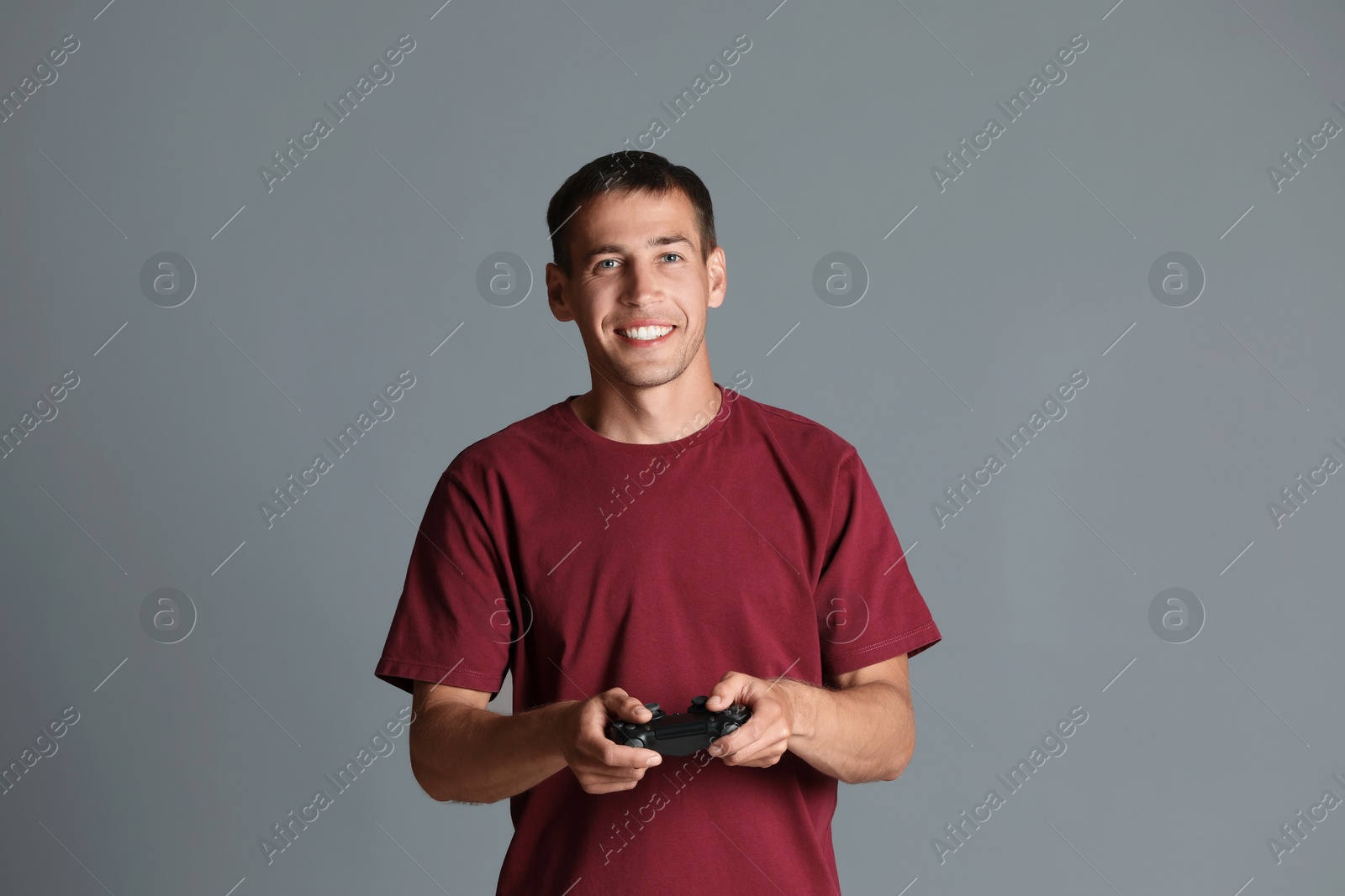 Photo of Happy man with controller on gray background