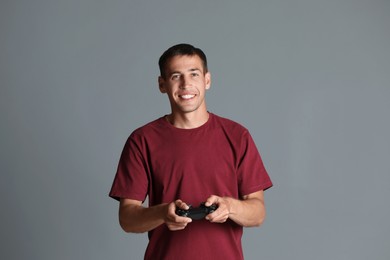 Photo of Happy man with controller on gray background